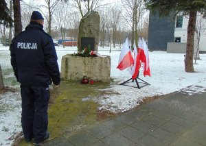 Na zdjęciu widać policjanta przy pomniku w Oświęcimiu