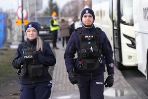 para policjantów patroluje drogę dojazdową do obozu