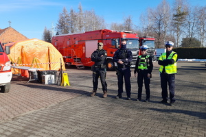 stojący obok siebie na parkingu policjanci prewenecji, kontrterrorysta i ruchu drogowego