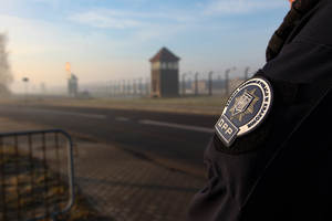 naszywka oddziału prewencji policji w tle obóz