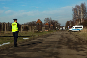 policjant patroluje drogę dojazdową przy obozie