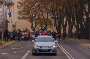 Zdjęcie policjanci pilotują pochód w tle uczestnicy uroczystości