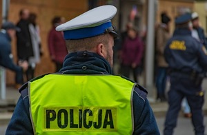 Zdjęcie policjant zabezpiecza przemarsz w tle strażnik miejski i uczestnicy