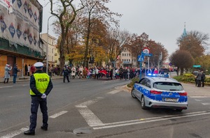 Zdjęcie  policjant na skrzyżowaniu zabezpiecza przemarsz