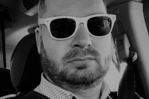 Szymon Chabior w okularach przeciwsłonecznych  zdjęcie czarno białe