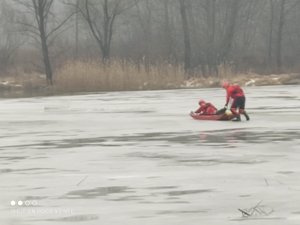 Strażacy na zamarzniętym stawie z saniami