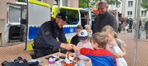 Policjanci i dzieci na stoisku policyjnym