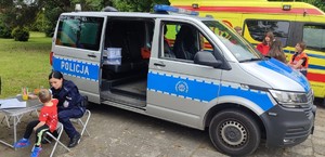Policjanci i dzieci na stoisku policyjnym