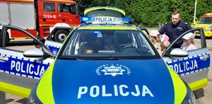 policjant z dziećmi przy radiowozie