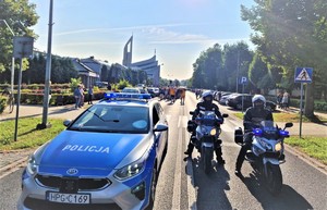 Zdjęcie radiowozu i motocykli policyjnych pilotujących pielgrzymkę