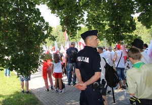 policjant przy ulicy obok przechodzi p[rocesja