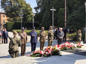 Na zdjęciu służby składają wieniec przed pomnikiem