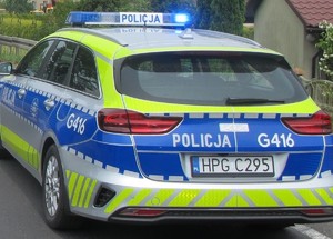 radiowóz z włączonymi światłami uprzywilejowania na ulicy