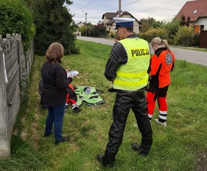 kierująca uczy się udzielania pierwszej pomocy obok policjant i uczennice