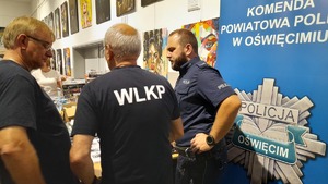 dzielnicowy z uczestnikami przy stoisku policyjnym