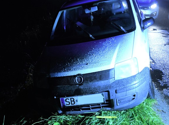 Uszkodzony fiat Panda na poboczu obok radiowóz