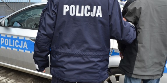 policjant z zatrzymanym przy radiowozie