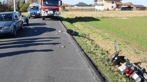 Skuter w rowie na jezdni samochód radiowóz i wóz strażacki