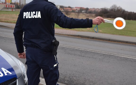 Policjant z tarczą do zatrzymywania pojazdów