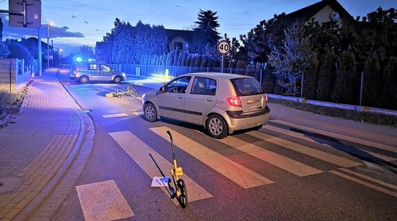 Miejsce potrącenia rowerzystki. Rower , samochód i radiowóz na ulicy.