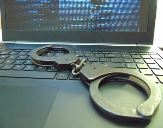Na zdjęciu laptop i kajdanki