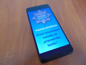 Zdjęcie telefon z ostrzeżeniem o oszustwie na pracownika banku