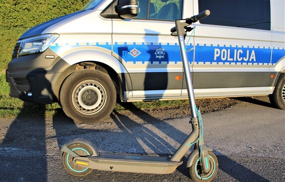 Na zdjęciu hulajnoga na tle radiowozu