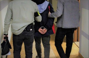 Na zdjęciu policjanci z zatrzymanym