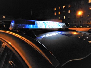 Zdjęcie radiowóz na tle bloków w nocy