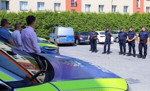 Na zdjęciu przekazywane radiowozy, przedstawiciele policji i gmin