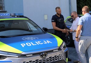Na zdjęciu przekazywane radiowozy, przedstawiciele policji i gmin