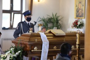 Na zdjęciu wnętrze kościoła. Trumna i stojący obok policjant z bronią.