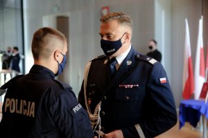 Na zdjęciach komendant wręcza nominacje policjantom i policjantkom przyjętym do służby w Policji.