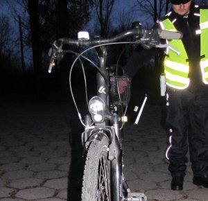 Na zdjęciu policjant stojący obok roweru.