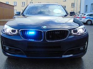 Na zdjęciu radiowóz BMW nieoznakowany z włączonymi sygnałami świetlnymi.