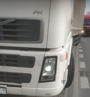 Na zdjęciu przód jednej ciężarówki w tle dróga ciężarówka