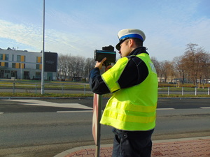 Na zdjęciu policjant ruchu drogowego z miernikiem w ręce