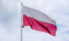 Na zdjęciu widać flagę Polski w kolorach  białym i czerwonym na drzewcu.