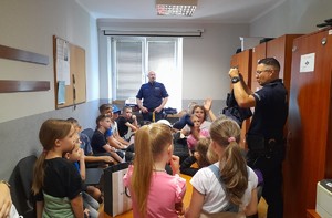 Policjant prezentuje dzieciom kamizelkę kuloodporną
