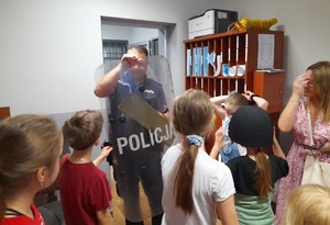 policjant prezentuje dzieciom tarczę